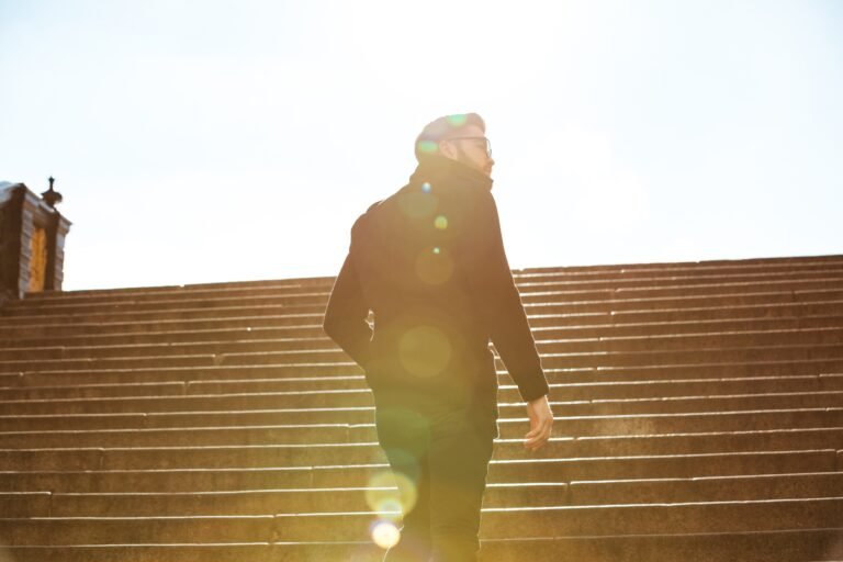 Back view of man walking on stairs outdoors